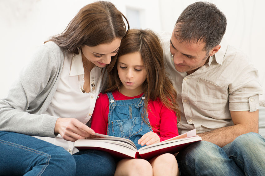 25271828 - mother and father helping their daughter while reading book