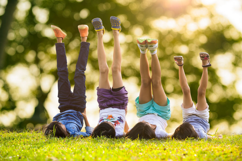 26772943 - group of happy children lying on green grass outdoors in spring park