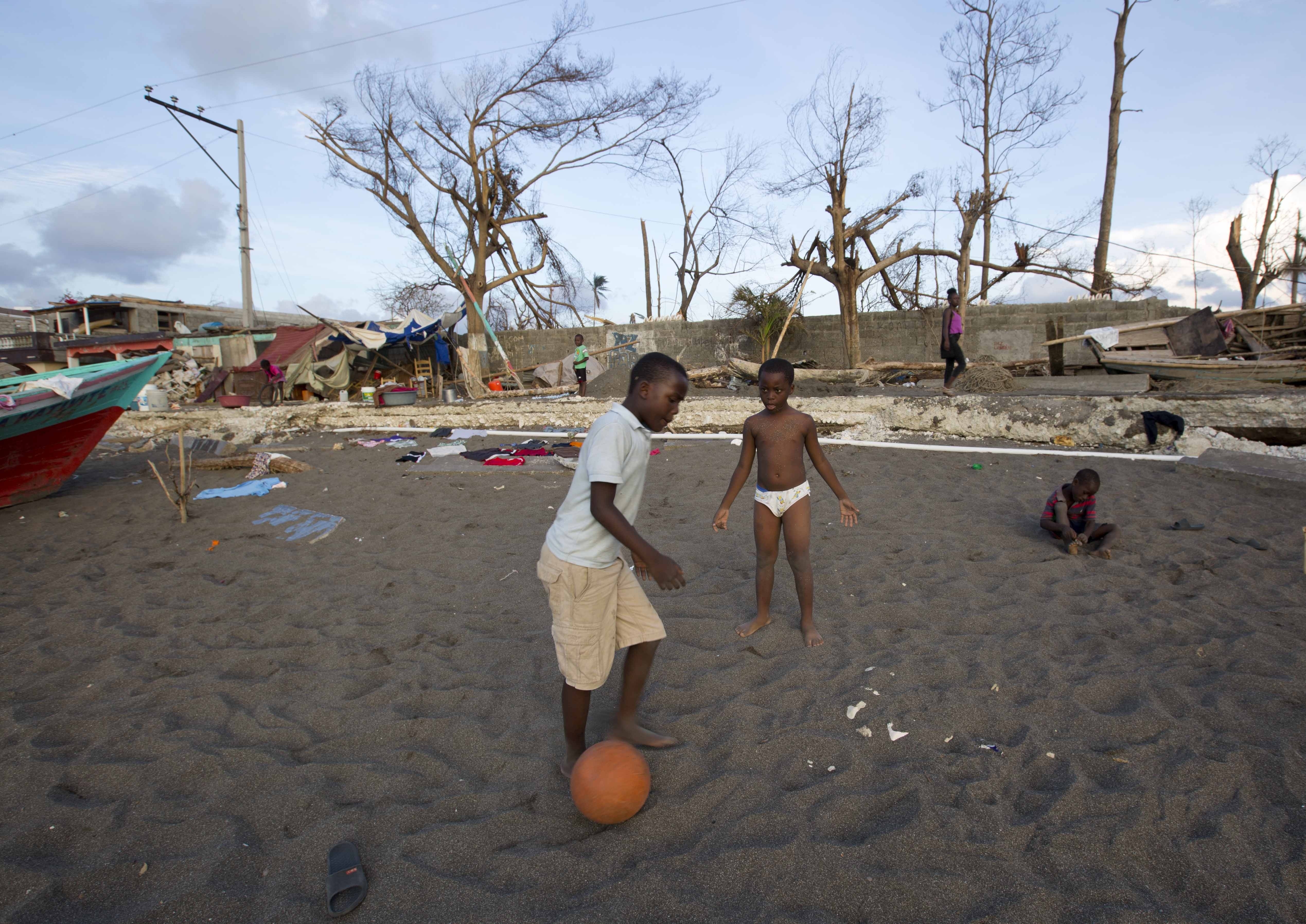 JB 28 Dame-Marie - Chlapci hrajú futbal na zemi znièeného domu po vyèíòaní hurikánu Matthew v meste Dame-Marie na Haiti 11. októbra 2016. Na minimálne 1000 vzrástol u poèet obetí hurikánu Matthew, ktorý minulý týdeò zasiahol ostrovný tát Haiti. Búrka tie pripravila desatisíce ¾udí o domovy a znièila úrodu v regióne oznaèovanom za obilnicu tejto chudobnej karibskej krajiny. Haiti cez víkend vyhlásilo trojdòový tátny smútok na poèes obetí, ktoré v nede¾u zaèali pochováva do masových hrobov, aby sa zabránilo íreniu cholery v postihnutých oblastiach. FOTO TASR/AP  Boys play soccer on the ground of a destroyed house after the Hurricane Matthew in Dame-Marie, Haiti on Tuesday, Oct. 11, 2016. Nearly a week after the storm smashed into southwestern Haiti, some communities along the southern coast have yet to receive any assistance, leaving residents who have lost their homes and virtually all of their belongings struggling to find shelter and potable water. (AP Photo/Dieu Nalio Chery)