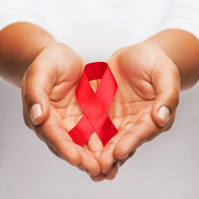 28653475 - healthcare and medicine concept - female hands holding red aids awareness ribbon