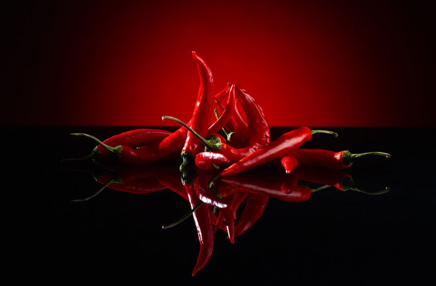 54569125 - beam of red chilli pepper on black background