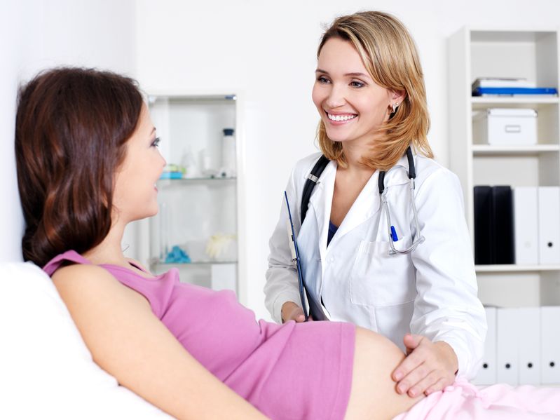 9083025 - happy doctor caring about young pregnant woman in hospital
