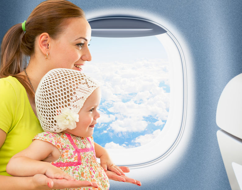 31238755 - happy mother and kid travelling together in airoplane cabin near window