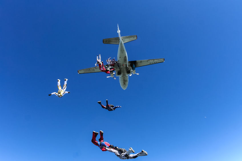 49348964 - a group of paratroopers jumping out of an airplane.