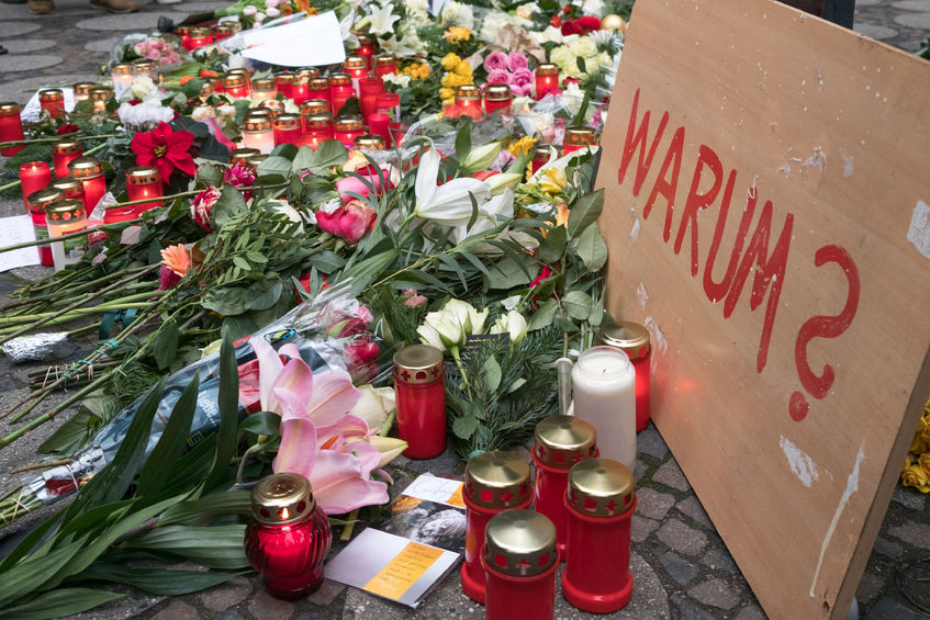 67937283 - berlin, germany - december 20, 2016: candles, flowers and a sign with the german word "why" (why) at christmas market in berlin, the day after the terrorist attack.