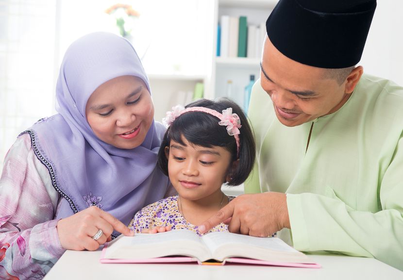 20434478 - malay muslim parents teaching child reading a book. southeast asian family at home.