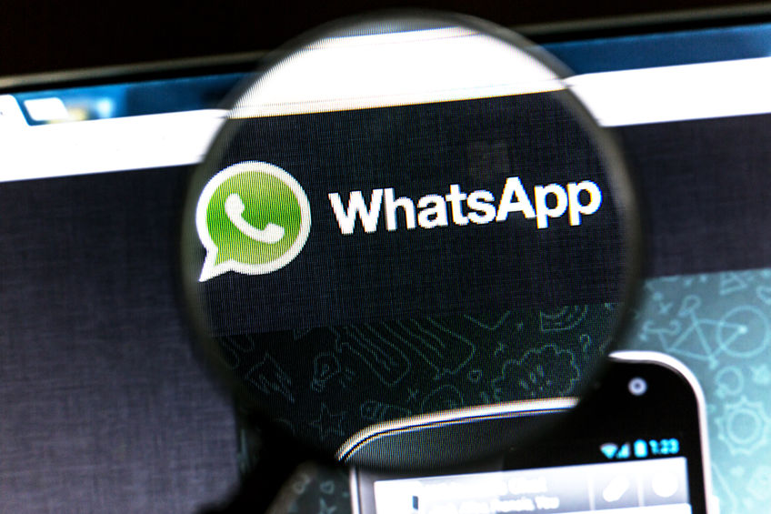43486900 - whatsapp website under a magnifying glass. whatsapp is an instant messaging app for smartphones.