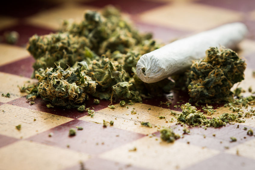 33884044 - closeup of marijuana joint and buds on a checkerboard table with a shallow depth of field