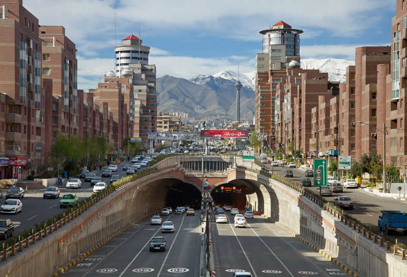 34082743 - cars passing through tohid tunnel of tehran with milad tower and alborz mountains in the background.