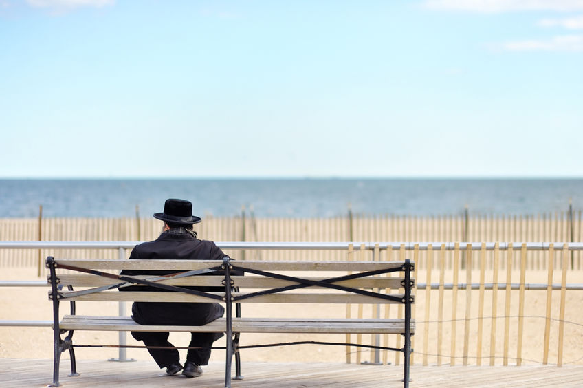 40682622 - unrecognizable jewish man sitting on wooden bench near ocean