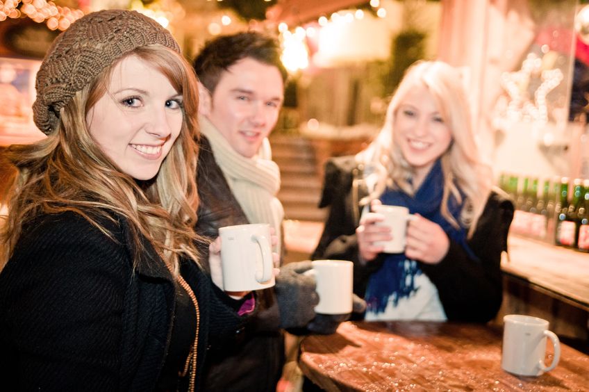 16253884 - three young people drinking punch at christmas market