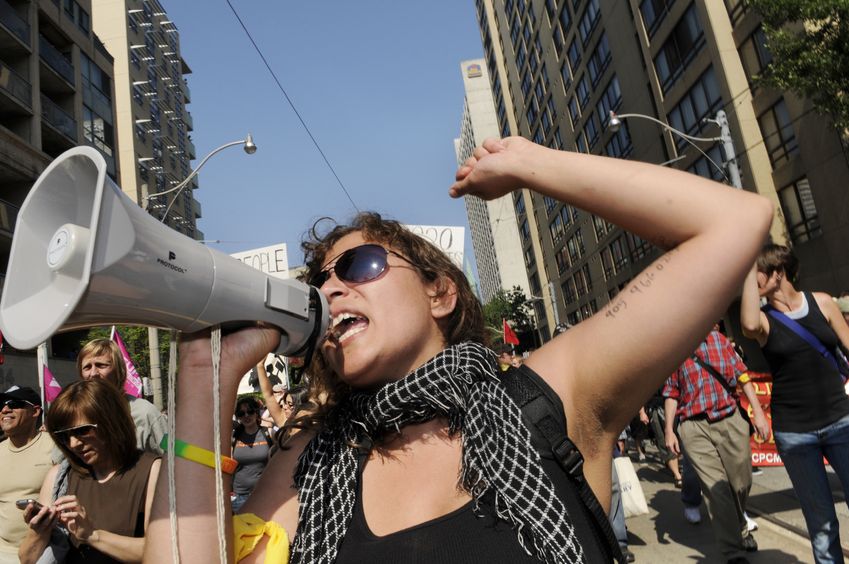 20264012 - toronto-june 25: an angry woman protester chanting slogans with a microphone during the g20 protest on june 25, 2010 in toronto, canada.