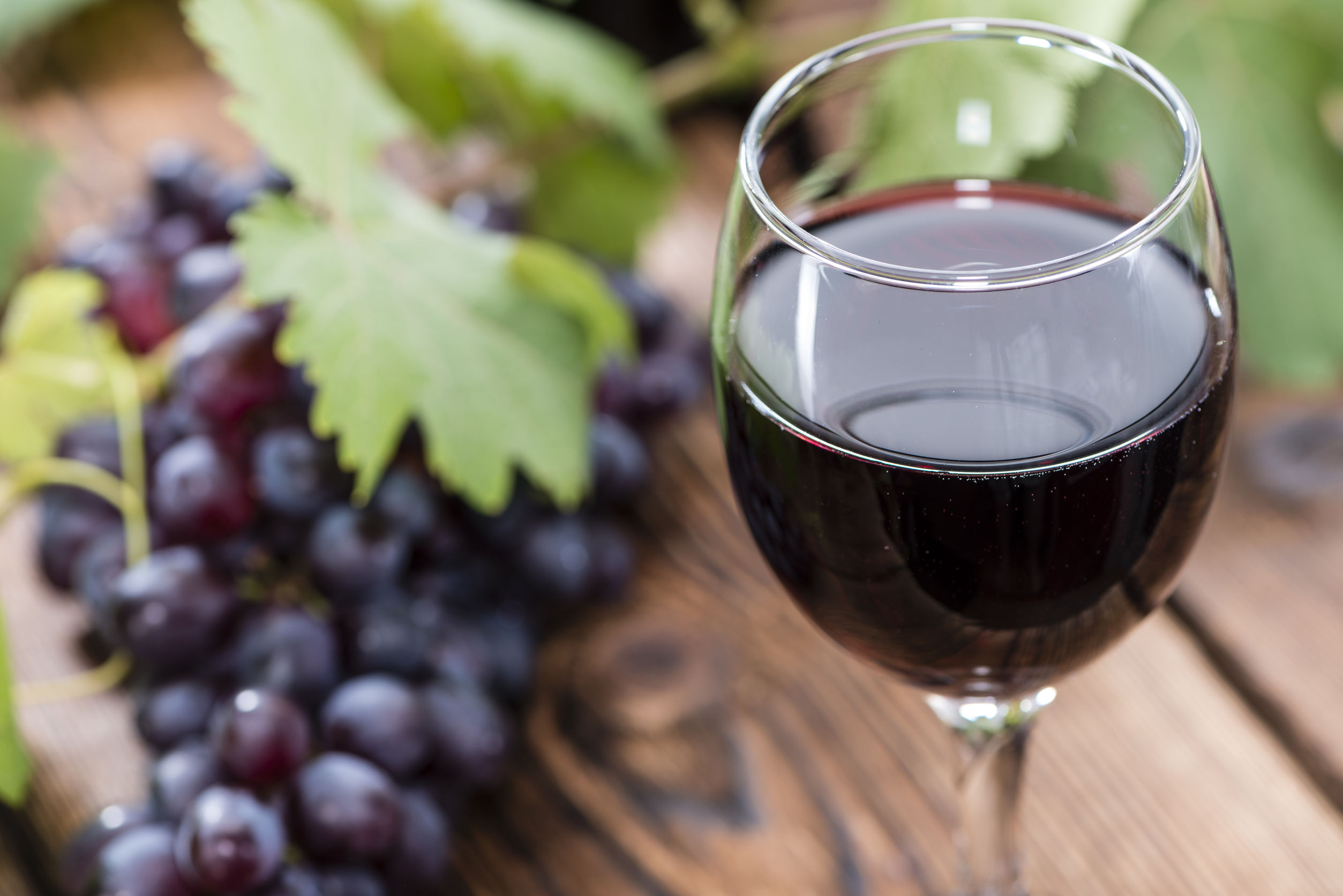 31331507 - glass with red wine and fresh grapes on wooden background
