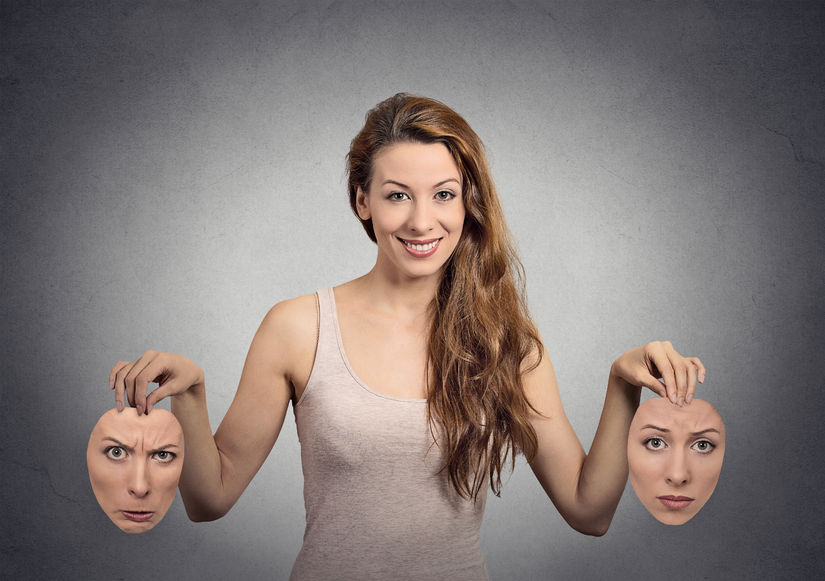 32554753 - portrait beautiful happy girl holds two masks isolated grey wall background. human face expressions, emotions, feelings, bipolar state of mind concept