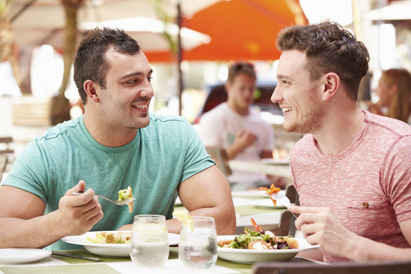 33546383 - male couple enjoying lunch in outdoor restaurant