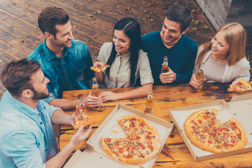 45174916 - enjoying time together. top view of five happy young people holding bottles with beer and eating pizza while standing outdoors