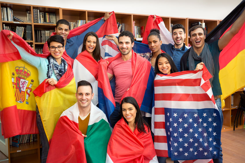 46092965 - international multiethnic exchange of students, happy students presenting their countries with flags