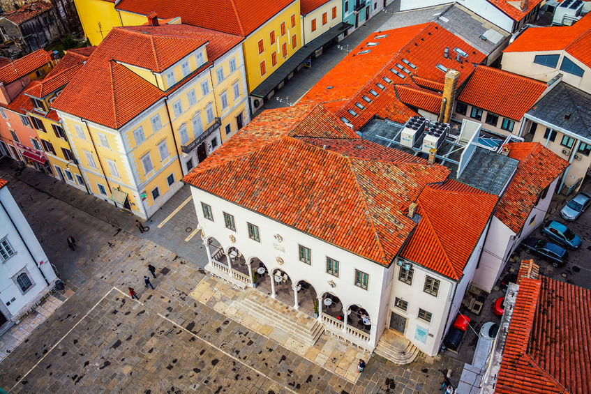 60003785 - central square of coastal town koper in slovenia seen from above. historical buildings with red roofs, cafes, shops and restaurants