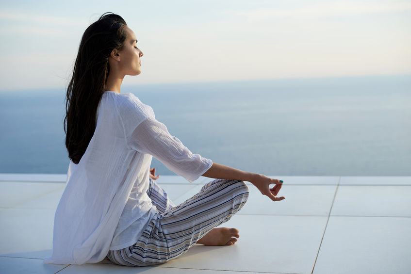 43315420 - young woman practice yoga meditaion on sunset with ocean view in background