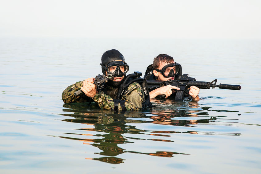 51068834 - navy seal frogmen with complete diving gear and weapons in the water