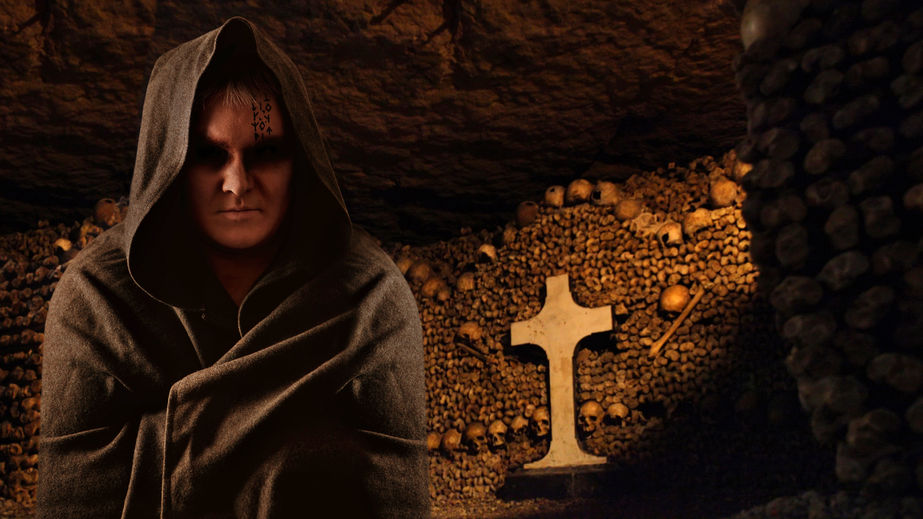 25997749 - praying monk in the dark paris catacombs