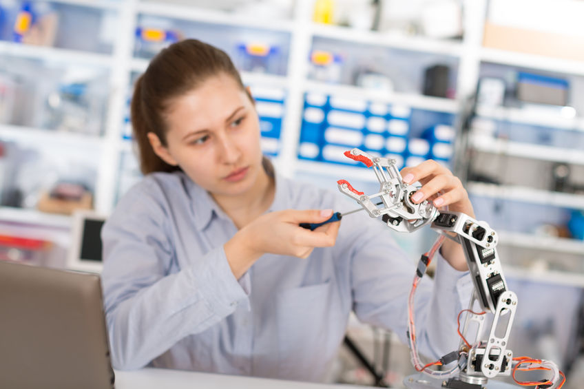 34147378 - schoolgirl adjusts the robot arm model, girl in a robotics laboratory
