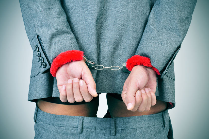 35827381 - a man in suit with his wrists locked in the back with sexy fluffy handcuffs and his pants down