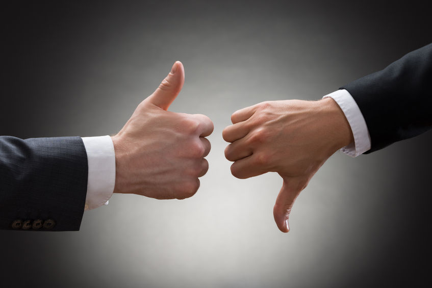 40870643 - close-up of two businesspeople hands showing thumb up and thumb down sign