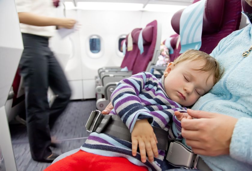18766839 - flying with children mother and sleeping two year old baby girl travel on a commercial airliner
