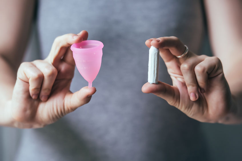41240424 - young woman hands holding different types of feminine hygiene products - menstrual cup and tampons