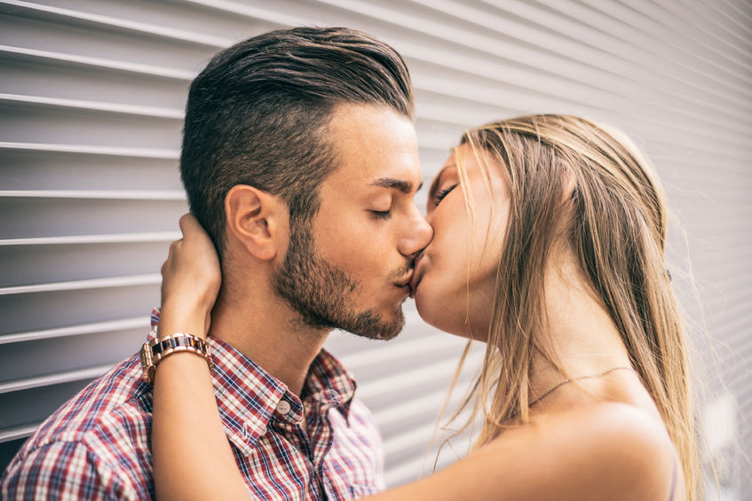 49080818 - couple of lovers kissing - beautiful young woman hugging and giving a kiss on her handsome boyfriend's lips