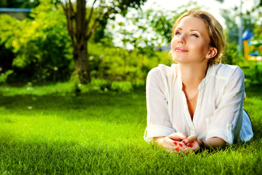 31798231 - beautiful smiling woman lying on a grass outdoor. she is absolutely happy.