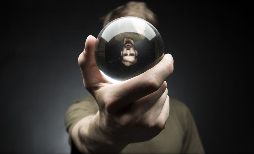 34556520 - young man holding a clear transparent crystal glass ball in their hand