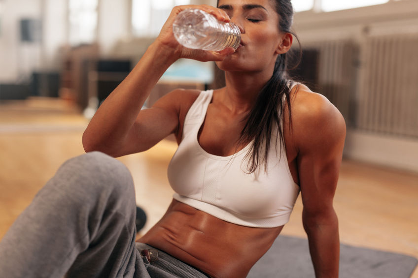 43852676 - fitness woman drinking water from bottle. muscular young female at gym taking a break from workout.