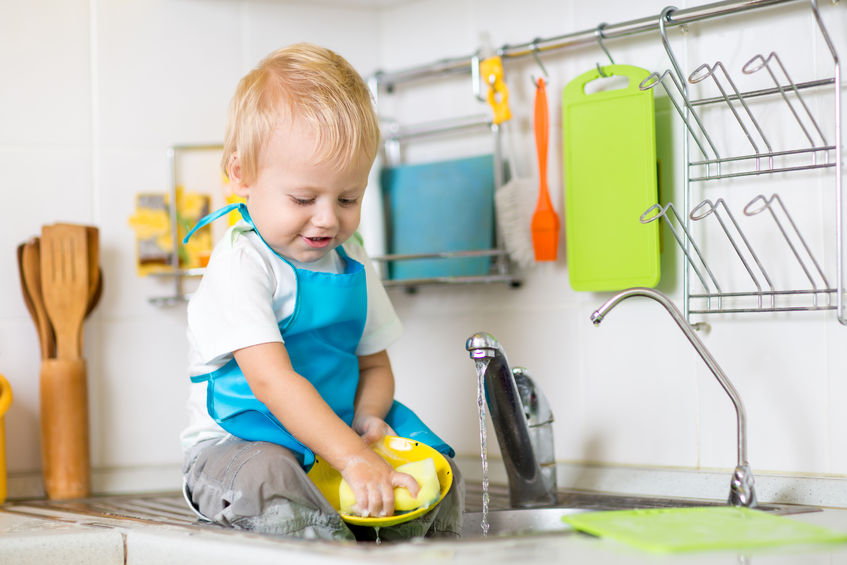 47999452 - cute child boy 2 years old washing up in kitchen