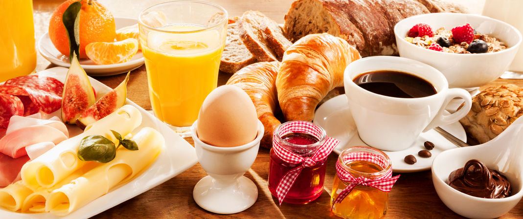 51721166 - breakfast feast with egg, meat, bread, coffee and juice