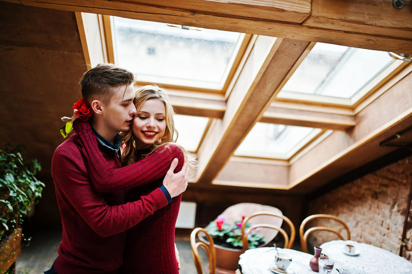 53938221 - young beautiful stylish couple in a red dress in love story at the vintage cafe with big windows at the roof