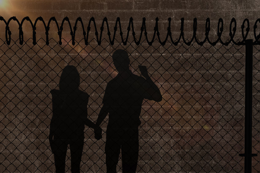 70222840 - happy couple walking holding hands against a dark wall