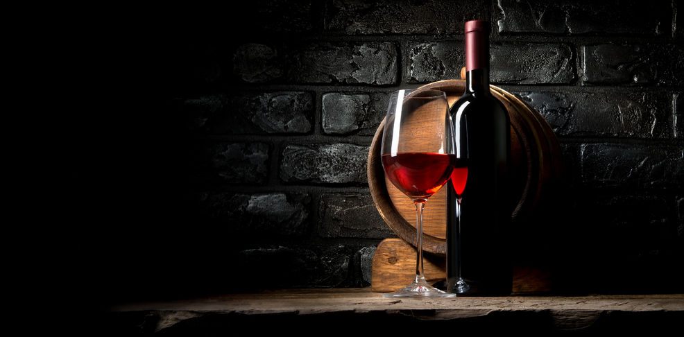 52587528 - red wine on a background of old black bricks