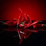 54569125 – beam of red chilli pepper on black background