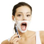 16762086 – beautiful young woman shaving her face with a razor