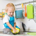 47999452 – cute child boy 2 years old washing up in kitchen